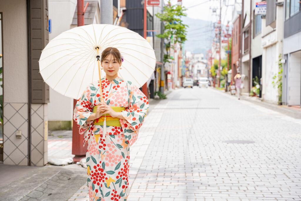 A beautiful woman in a yukata strolling around a shrine.